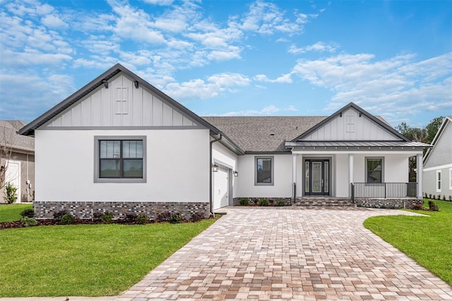 modern inspired farmhouse featuring a front lawn, a porch, and a garage