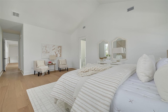 bedroom featuring high vaulted ceiling and light hardwood / wood-style floors