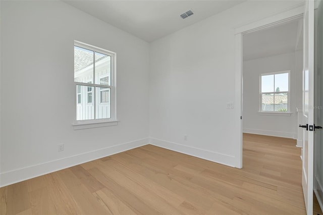 spare room featuring light hardwood / wood-style flooring and a wealth of natural light