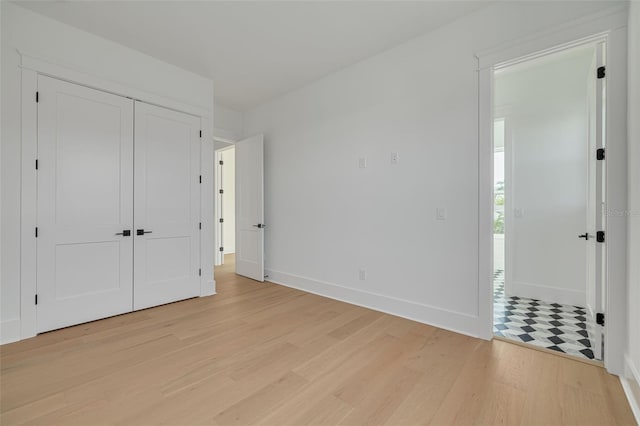 unfurnished bedroom with light hardwood / wood-style floors and a closet