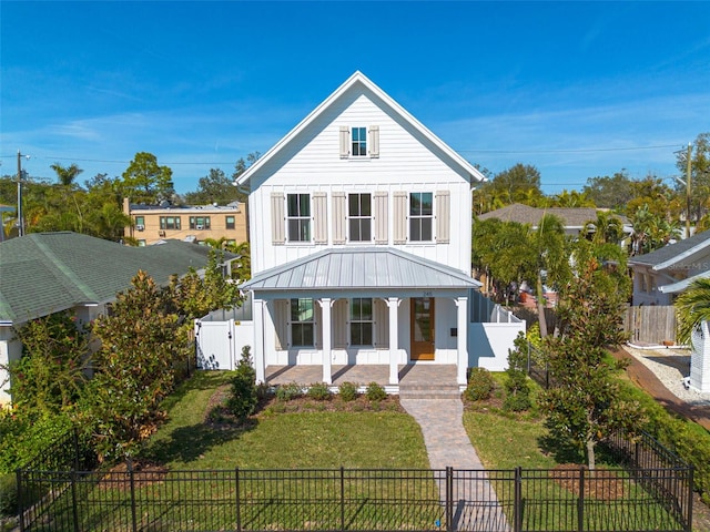 modern farmhouse style home with a front yard and a porch