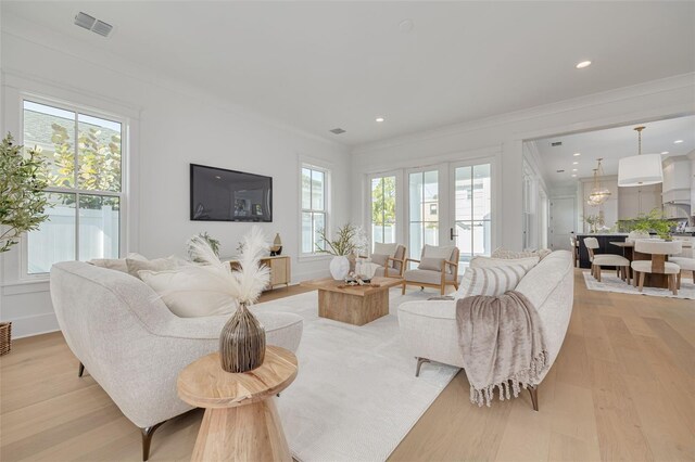 living room featuring crown molding and light hardwood / wood-style floors