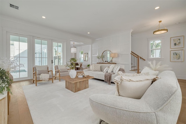 living room featuring light hardwood / wood-style flooring and ornamental molding