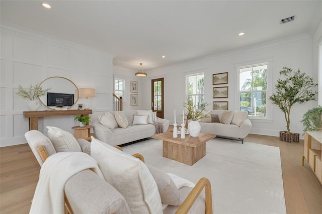 living room with crown molding and light wood-type flooring