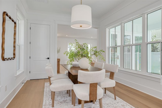 dining area featuring crown molding, light hardwood / wood-style flooring, and plenty of natural light