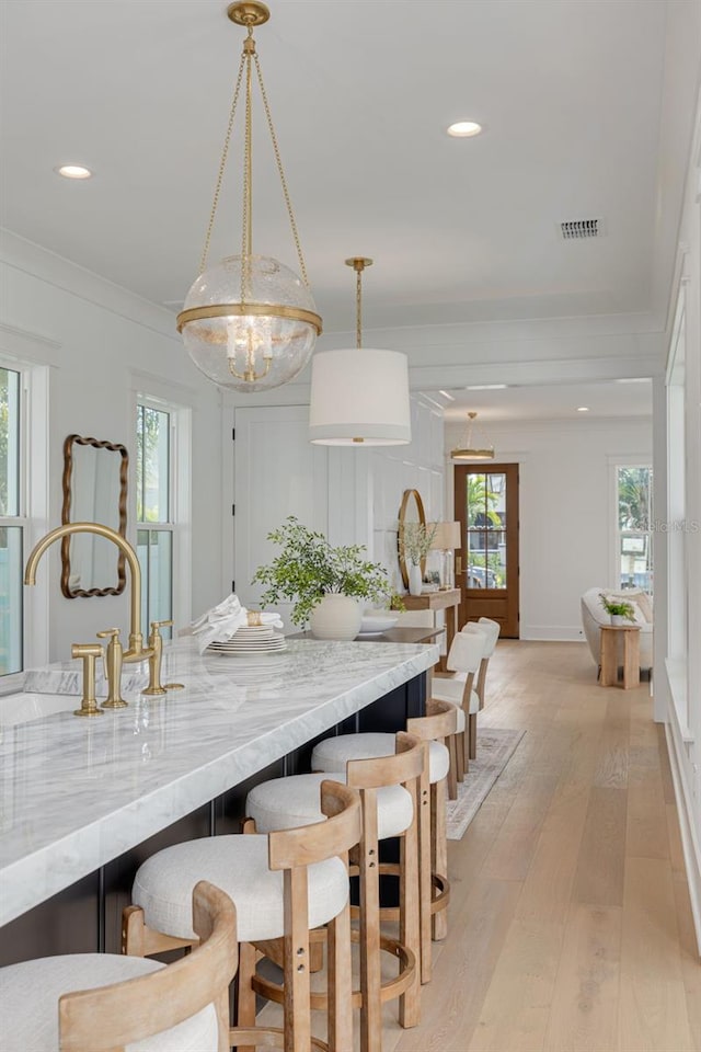 dining room featuring crown molding, sink, and light hardwood / wood-style floors