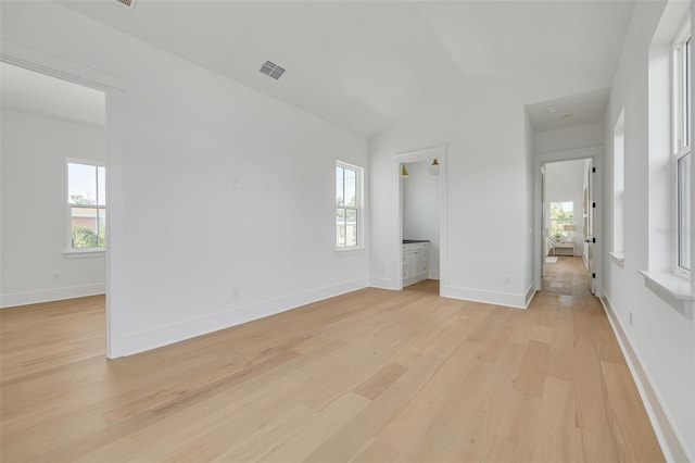 interior space featuring plenty of natural light, lofted ceiling, and light hardwood / wood-style floors