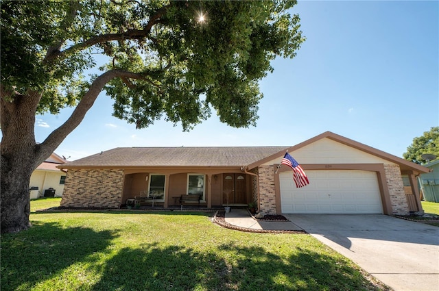 ranch-style home featuring a garage, a front yard, concrete driveway, and brick siding