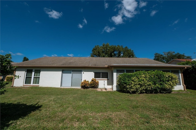 back of house with a yard and stucco siding