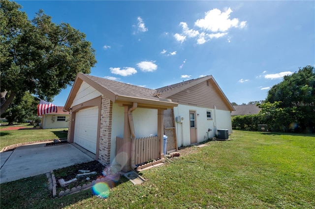 view of side of home with central AC unit, a lawn, and brick siding