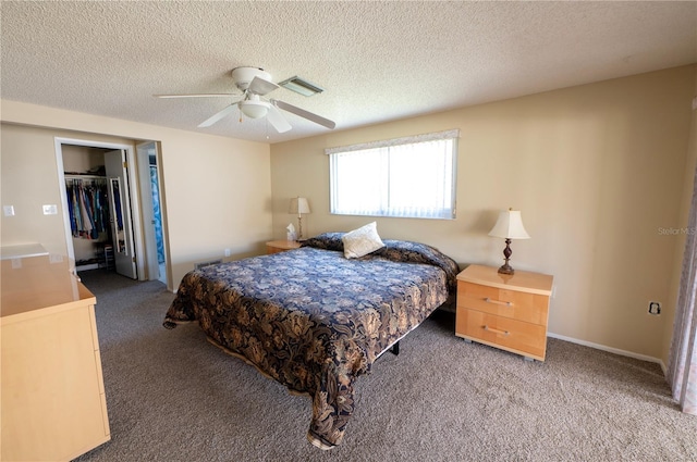 carpeted bedroom featuring a closet, visible vents, a spacious closet, ceiling fan, and a textured ceiling