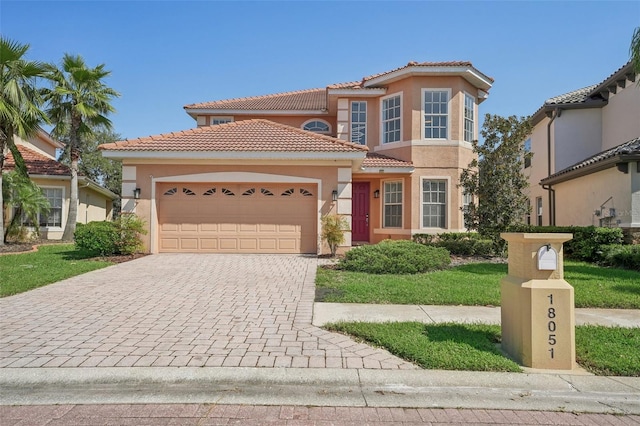 18051 Java Isle Dr, Tampa, FL 33647 - mediterranean / spanish-style house with stucco siding, a tiled roof, an attached garage, and decorative driveway