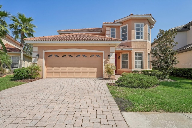 mediterranean / spanish-style home featuring a front lawn and a garage