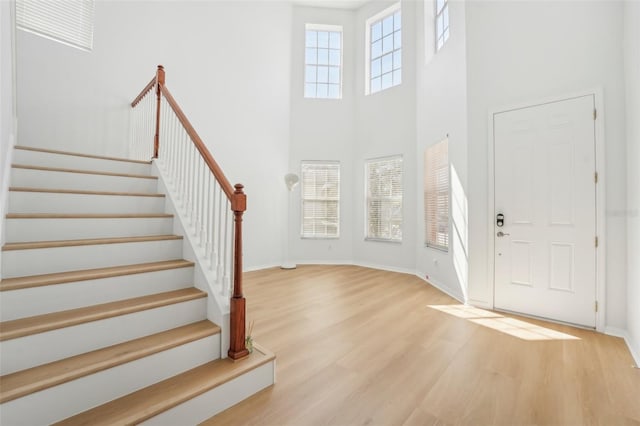 entryway with light hardwood / wood-style flooring and a high ceiling