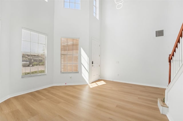 entrance foyer with a towering ceiling and light wood-type flooring