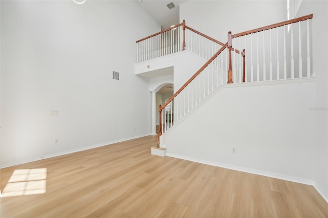 unfurnished living room with hardwood / wood-style flooring and high vaulted ceiling