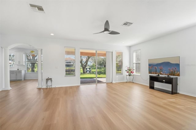 18051 Java Isle Dr, Tampa, FL 33647 - unfurnished living room featuring ornate columns, ceiling fan, light wood-type flooring, baseboards, and arched walkways