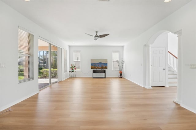 unfurnished living room featuring ornate columns, light hardwood / wood-style floors, and ceiling fan