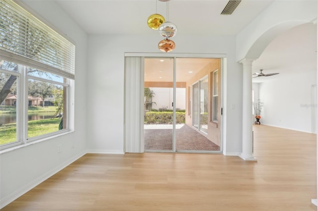 interior space featuring ornate columns, light wood-type flooring, and ceiling fan