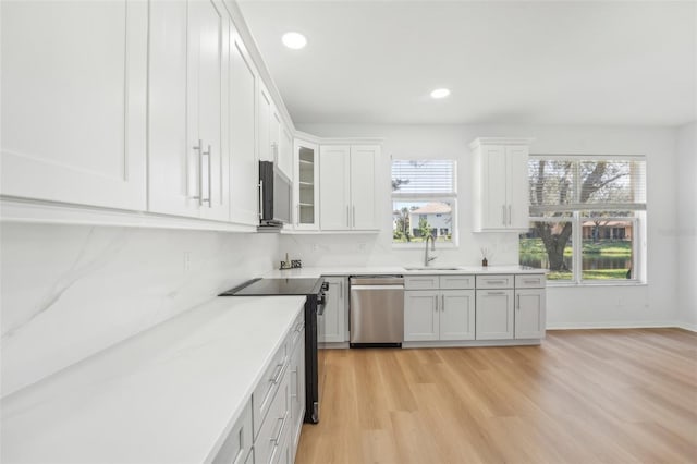 kitchen featuring sink, appliances with stainless steel finishes, white cabinets, and light hardwood / wood-style floors