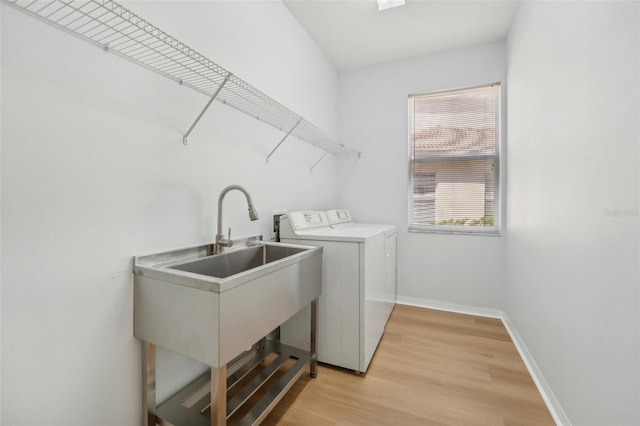 laundry room featuring sink, independent washer and dryer, and light wood-type flooring