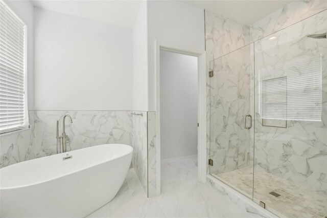 bathroom featuring plus walk in shower and tile walls