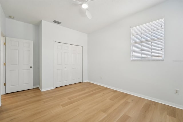 unfurnished bedroom featuring light hardwood / wood-style flooring, a closet, and ceiling fan