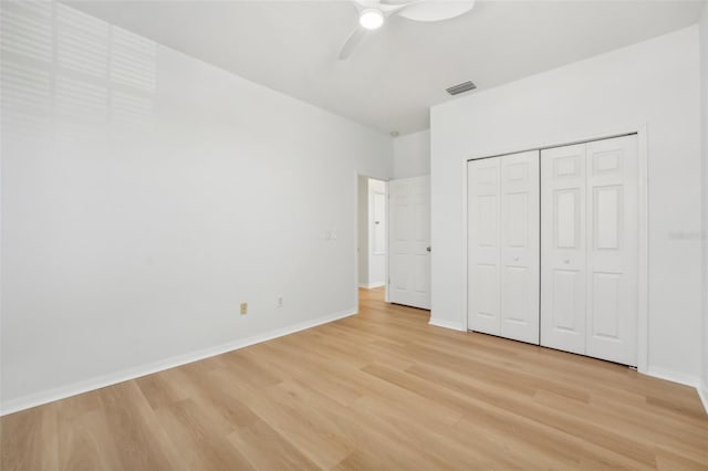 unfurnished bedroom with a closet, light hardwood / wood-style floors, and ceiling fan