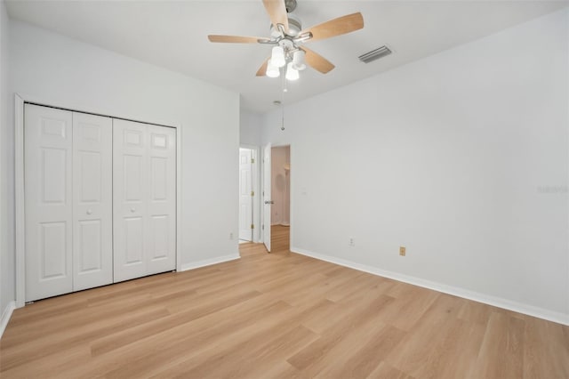 unfurnished bedroom with a closet, light wood-type flooring, and ceiling fan