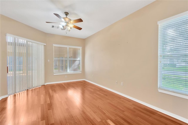 empty room with light hardwood / wood-style floors, a healthy amount of sunlight, and ceiling fan