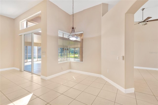 unfurnished dining area with light tile patterned floors and ceiling fan