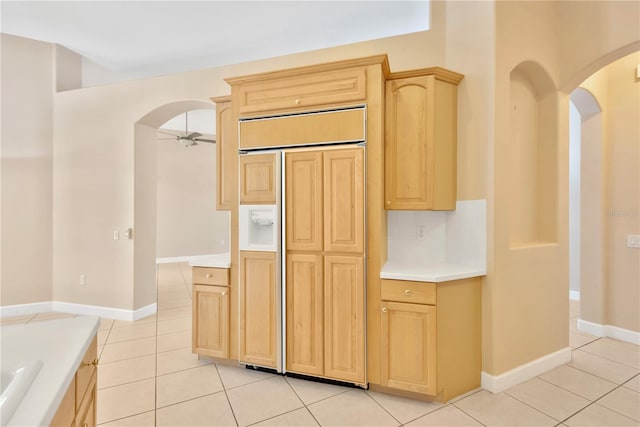 kitchen featuring ceiling fan, light tile patterned flooring, light brown cabinetry, and paneled refrigerator