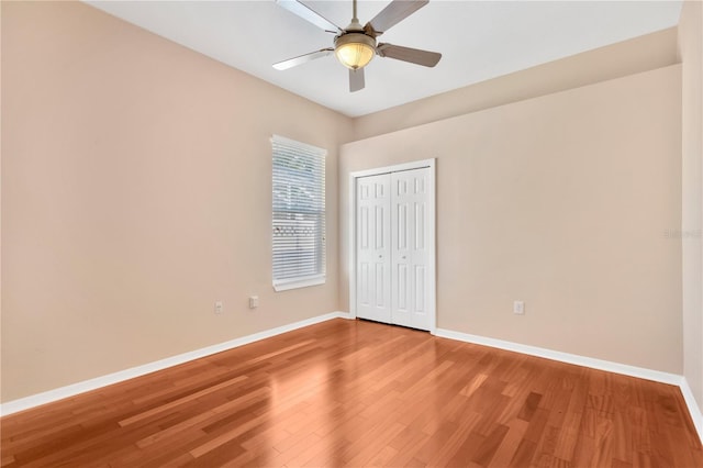 unfurnished bedroom with a closet, hardwood / wood-style floors, and ceiling fan