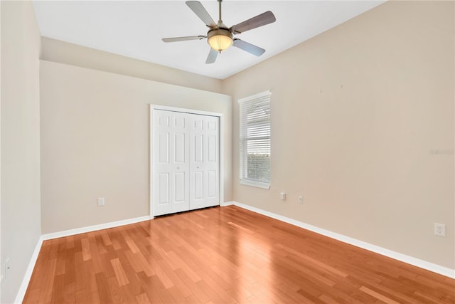 unfurnished bedroom featuring light hardwood / wood-style floors, a closet, and ceiling fan