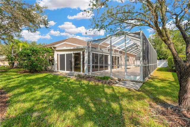 back of house with a patio, a swimming pool, a lawn, and a lanai