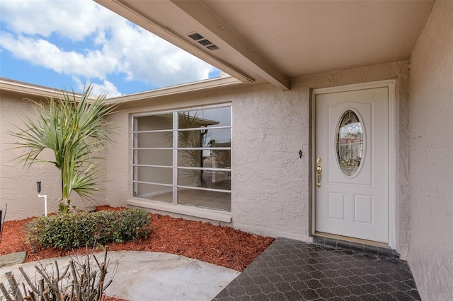 doorway to property with stucco siding