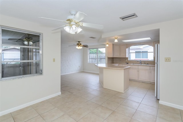 kitchen featuring tasteful backsplash, visible vents, light countertops, light tile patterned floors, and freestanding refrigerator