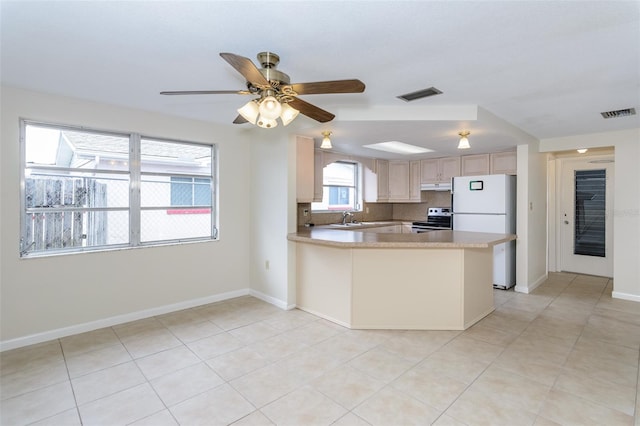 kitchen with light brown cabinets, visible vents, light countertops, stainless steel electric range, and freestanding refrigerator