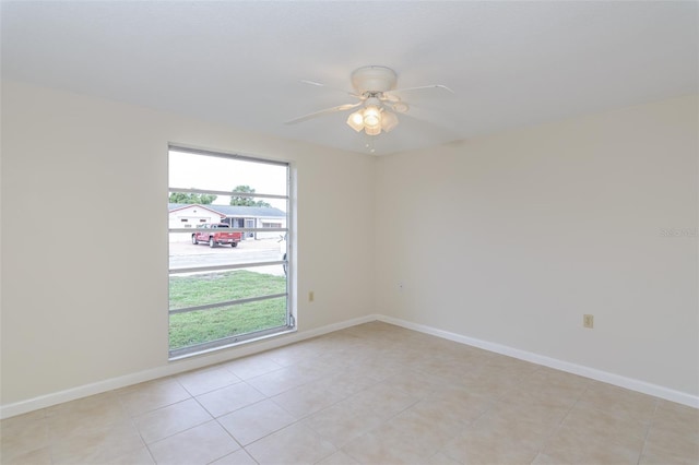 unfurnished room featuring light tile patterned floors, baseboards, and ceiling fan