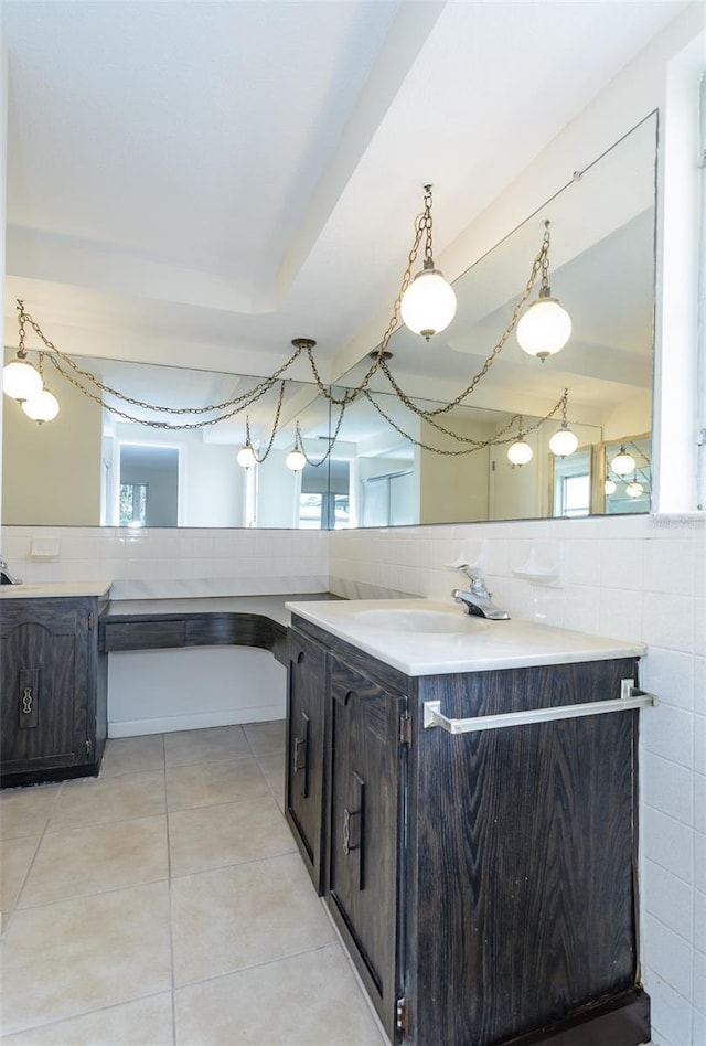 kitchen featuring decorative light fixtures, a sink, tile walls, light countertops, and light tile patterned floors