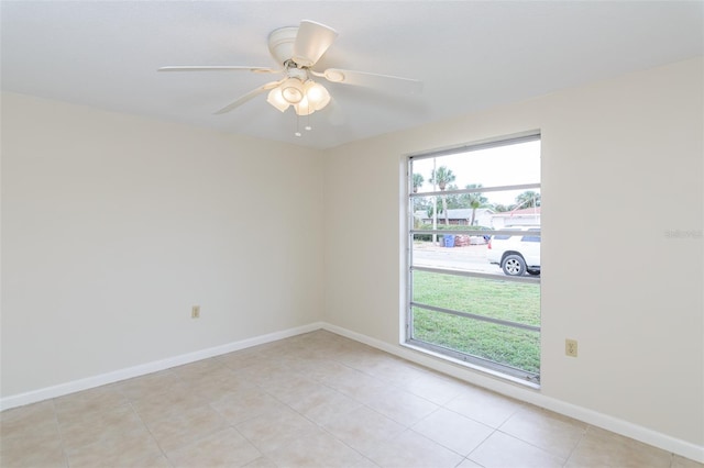 empty room with ceiling fan, baseboards, and light tile patterned flooring