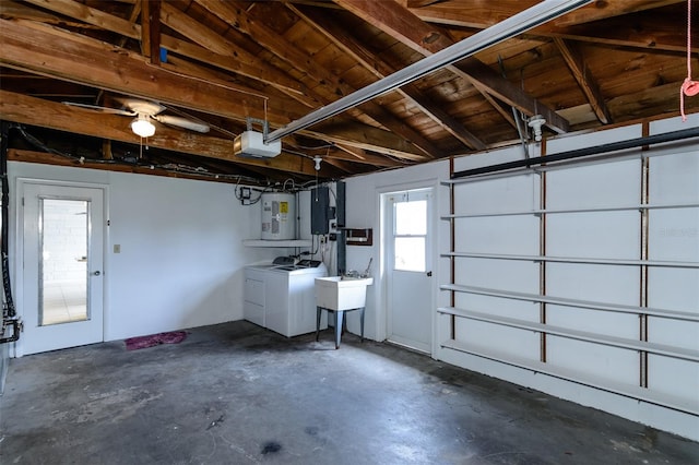 garage with separate washer and dryer, a sink, electric panel, and a garage door opener