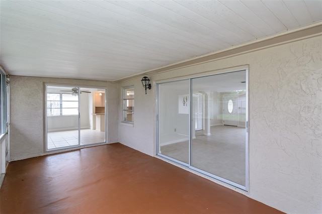 unfurnished sunroom with a ceiling fan