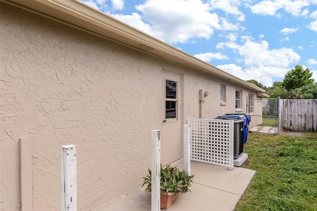 view of home's exterior with a gate, fence, and stucco siding