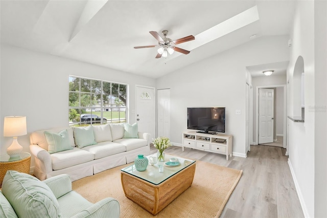 living room with ceiling fan, vaulted ceiling, and light wood-type flooring