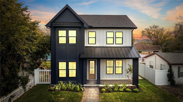 modern inspired farmhouse with board and batten siding, a standing seam roof, and fence