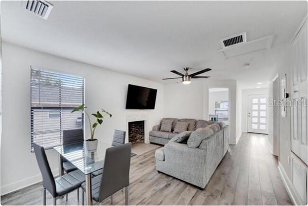 living room with light hardwood / wood-style floors and ceiling fan