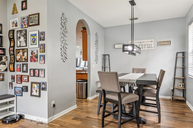 30552 Latourette Dr, Wesley Chapel, FL 33545 - dining area featuring arched walkways, wood finished floors, and baseboards