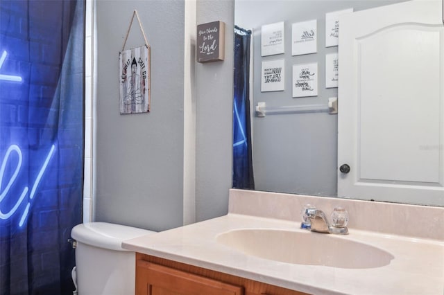 bathroom featuring toilet, a shower with curtain, and vanity