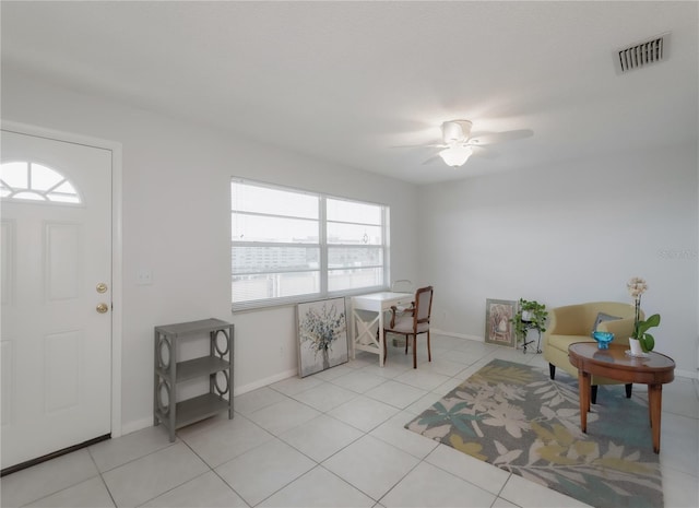 entrance foyer featuring ceiling fan, light tile patterned floors, and a healthy amount of sunlight